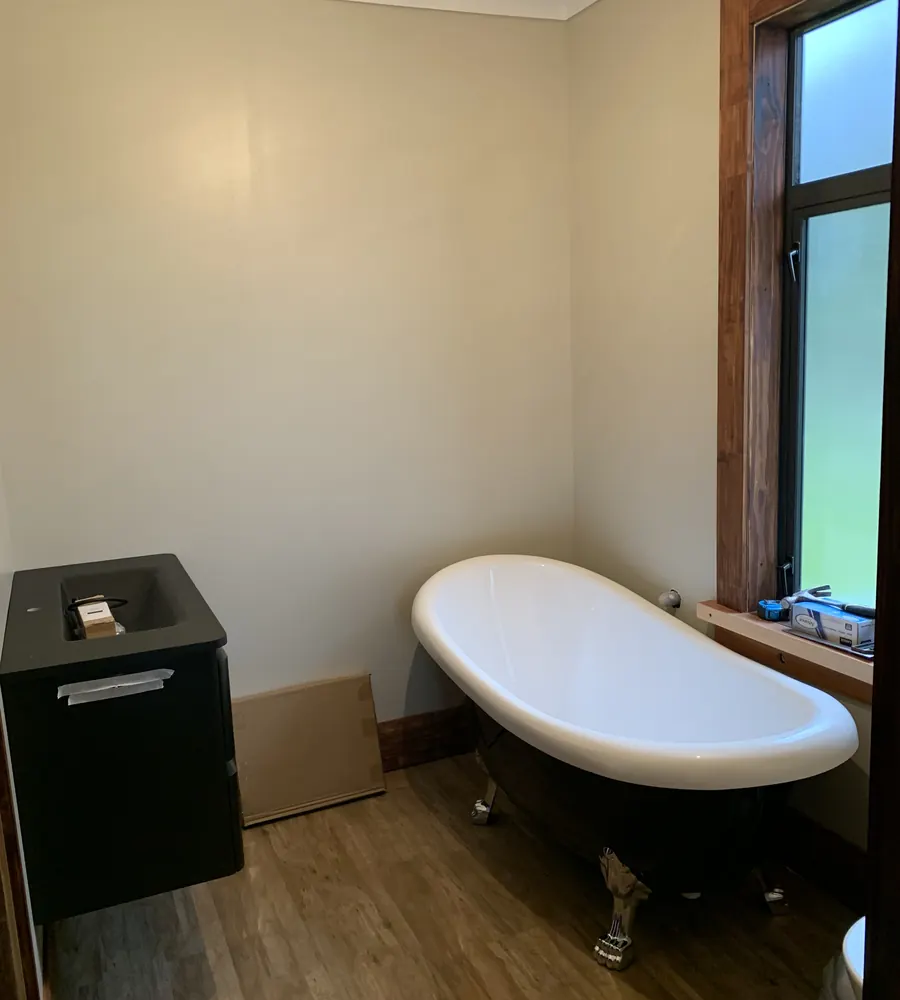 Bathroom with a clawfoot bath and timber window